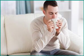 Un bărbat bea ceai cu mentă, dorind să vindece disfuncția erectilă. 